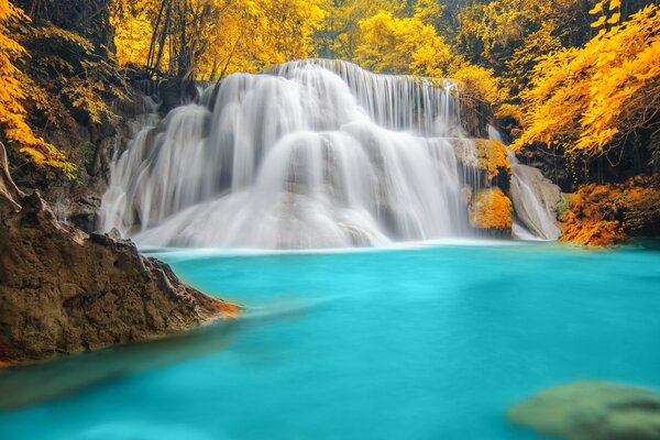 Paysage d automne d une cascade sur un lac bleu entouré de forêt jaune