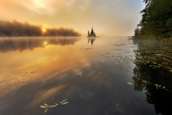 Herbstsee. Die Blätter schweben im Wasser. Tempel in der Ferne