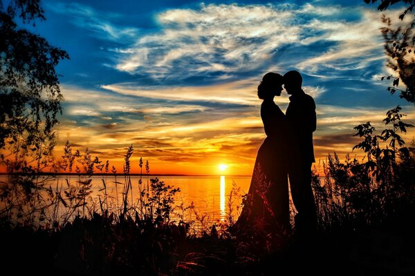 Pareja enamorada junto al mar al atardecer