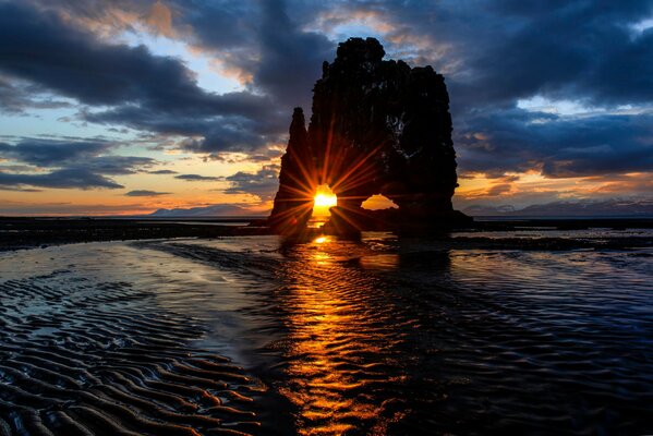 Rocher, mer sur fond de coucher de soleil