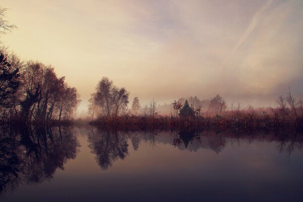 Lago mágico por la mañana en la niebla