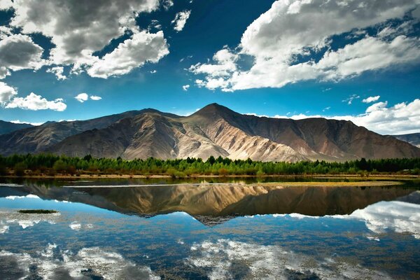 Majestuosas montañas y nubes se reflejan en la superficie del espejo del lago