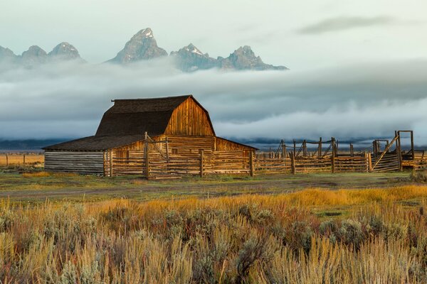 A lonely farm in the wild mountains, shrouded in fog