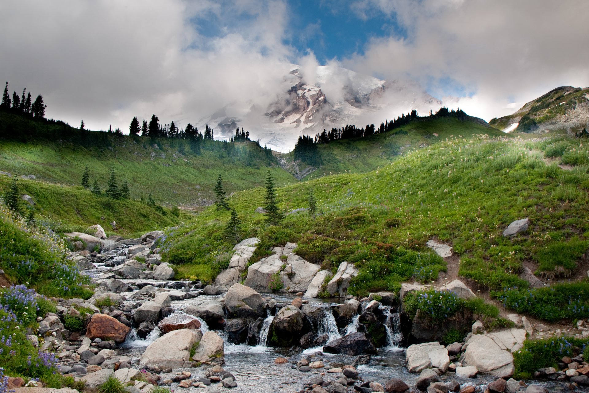 paesaggio montagne cielo nuvole fiume pietre ruscello erba alberi acqua