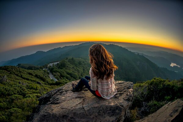 Fille admire au coucher du soleil de haute altitude