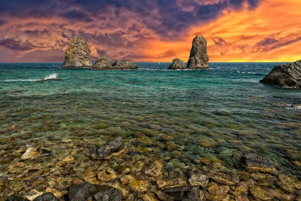 The blazing sky over the rocky seashore