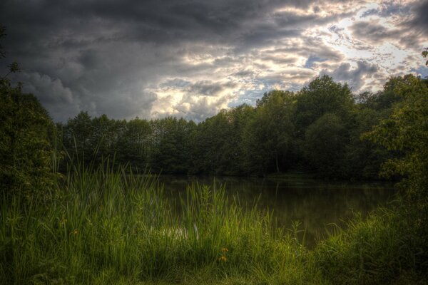 The arrival of summer rain over a small lake