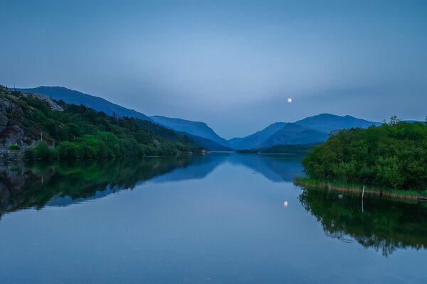 A quiet night with a full moon by a lake in Wales