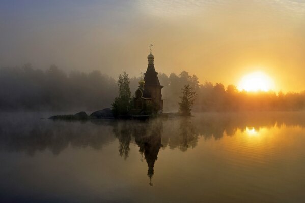 Reflection of the church at sunset in the fog