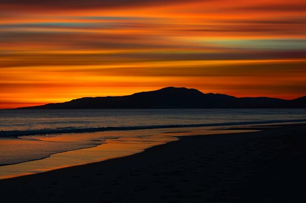 Puesta de sol naranja en la playa del mar