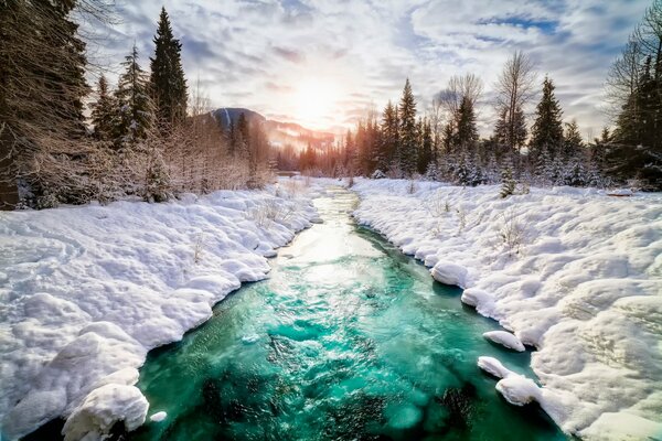 Ein Fluss in Kanada mit Schnee unter den Wolken