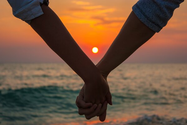 Love holding hands at sunset