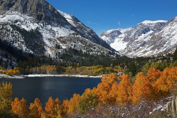 A lake among snowy mountains and yellow trees