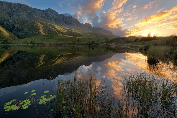 Lago de montaña refleja las tierras circundantes