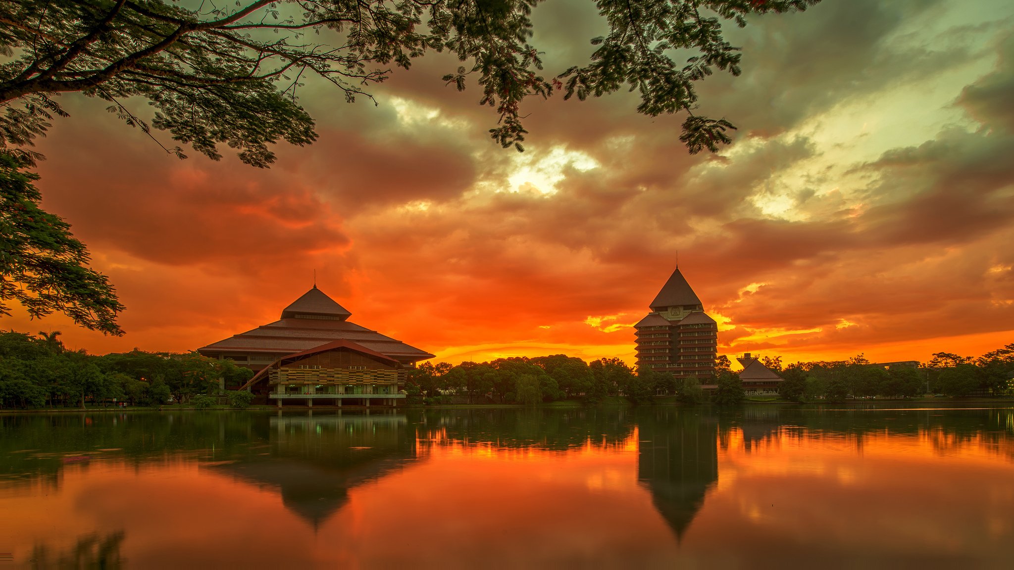 indonesien java insel stadt depok universität gebäude bäume fluss abend sonnenuntergang orange himmel wolken reflexion