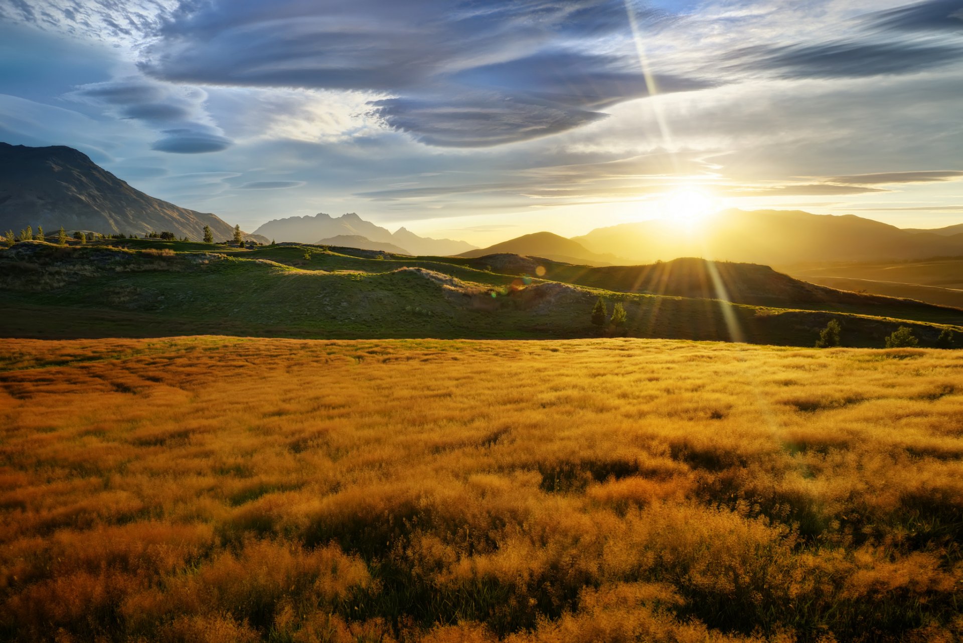 neuseeland berge hügel feld gras sonne strahlen blendung wolken