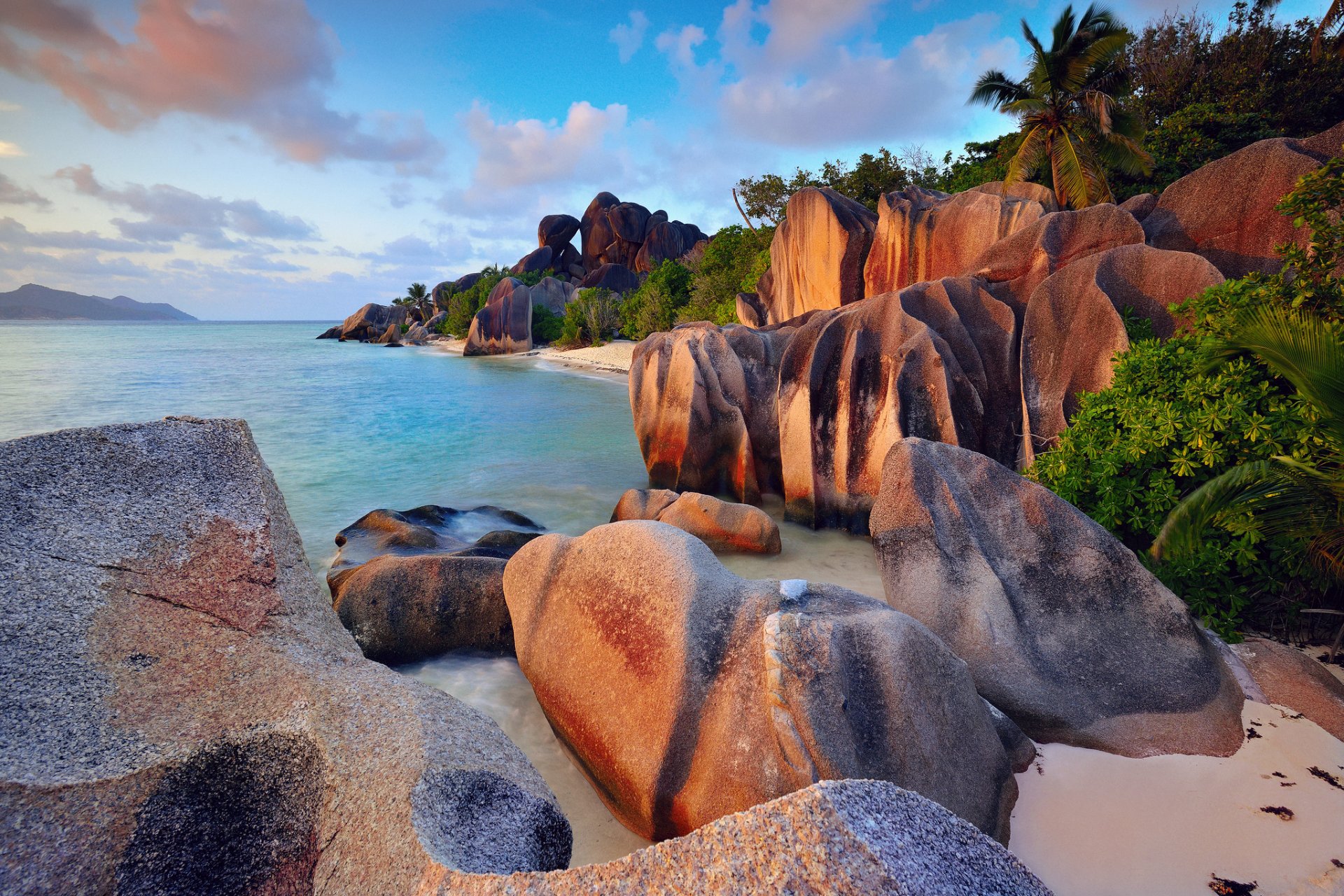 seychelles isla de la digue océano índico mar rocas acantilados playa palmeras árboles arbustos cielo nubes