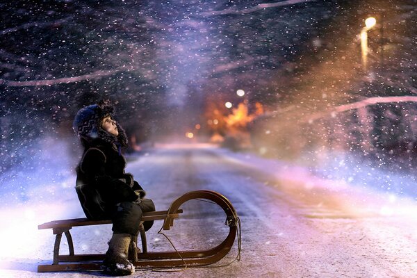 A child on a sled looks at the snow