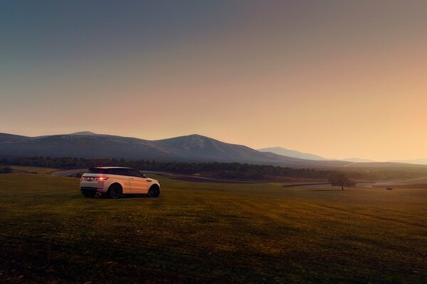 Voiture sur une colline au milieu d un champ