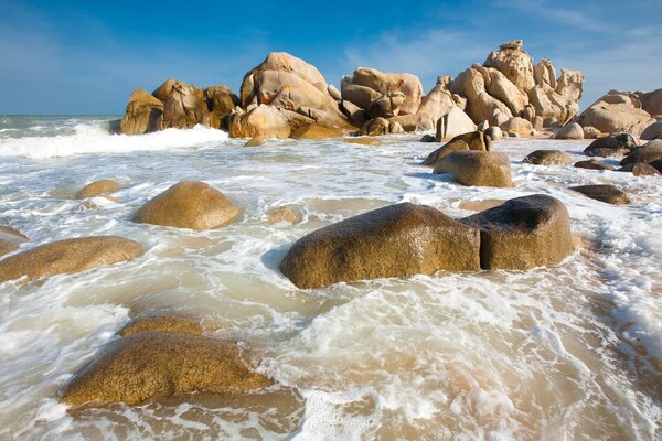 Волны моря разбиваются о камни на берегу