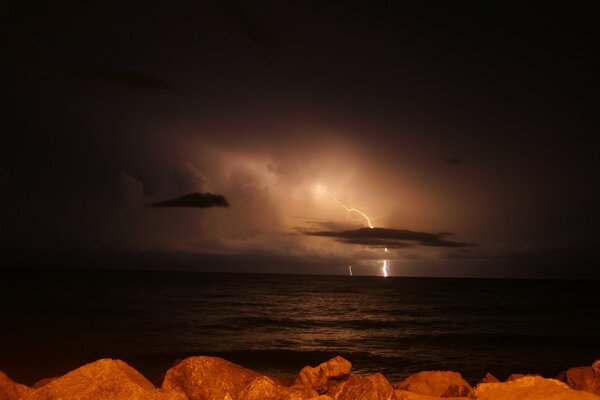 Night thunderstorm illuminates the sea