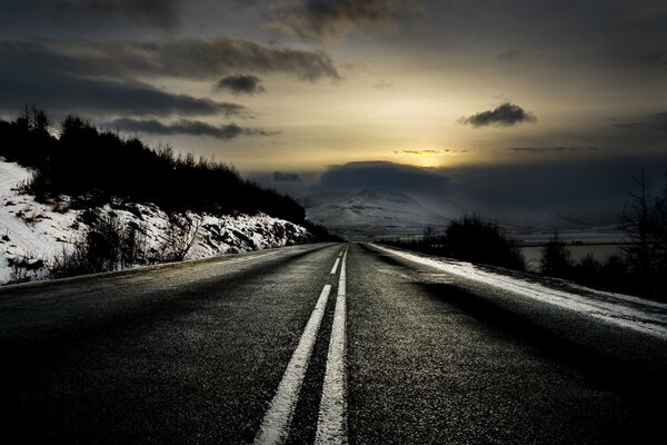El camino que sale en la distancia, al amanecer en invierno
