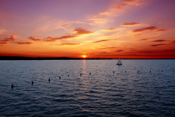 Yacht at sea on the background of a red sunset