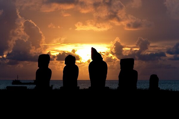Ídolos de la isla de Pascua en el fondo de una puesta de sol ardiente