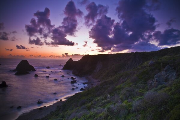 Coucher de soleil sur la plage de l océan rocheux