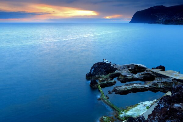 Isola di rocce sul mare al tramonto