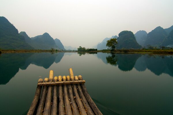 Bamboo pier and lake on the background of mountains