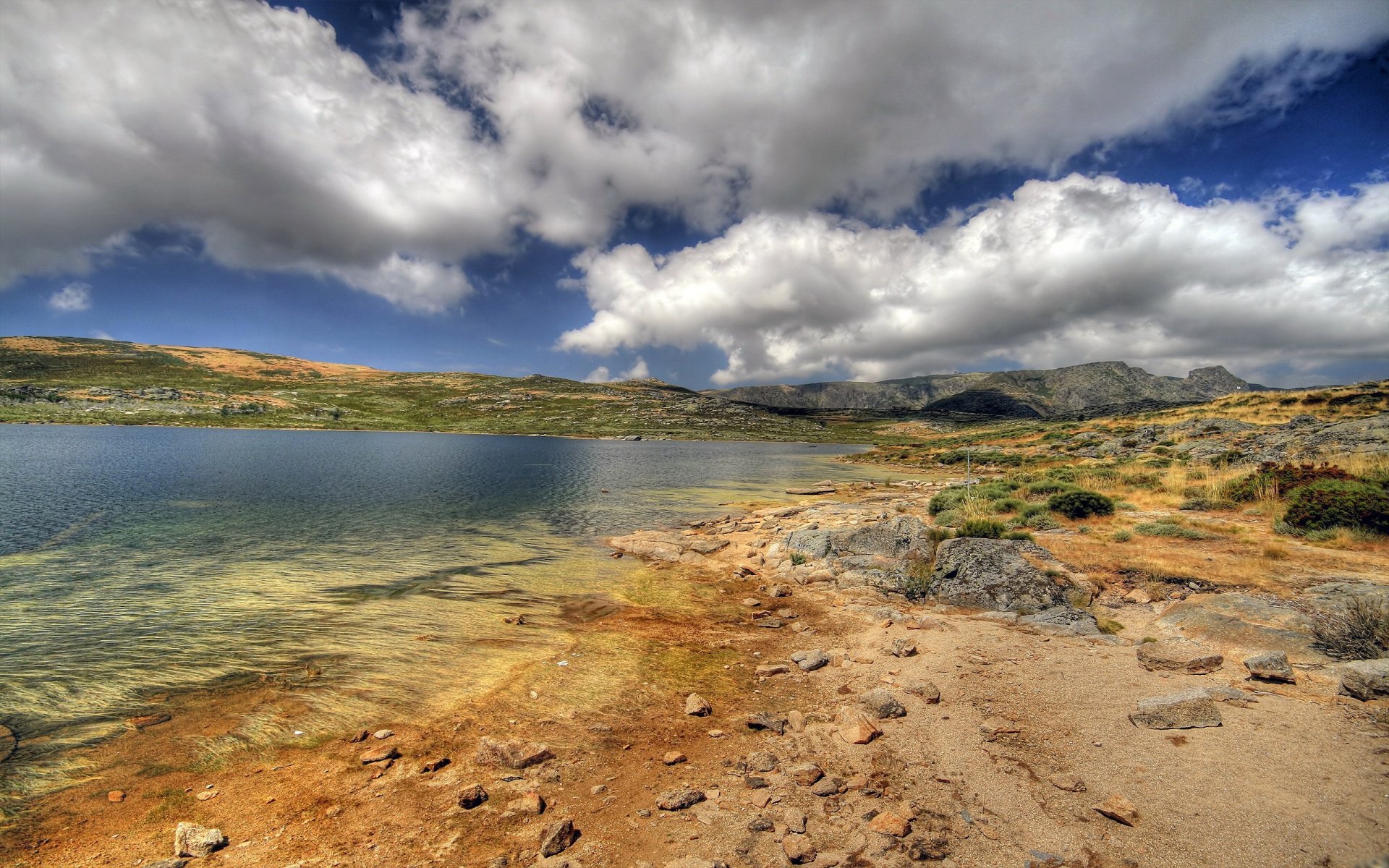 lago riva rocce nuvole