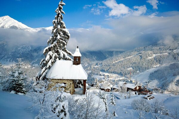 Pequeña casa en las montañas cubiertas de nieve