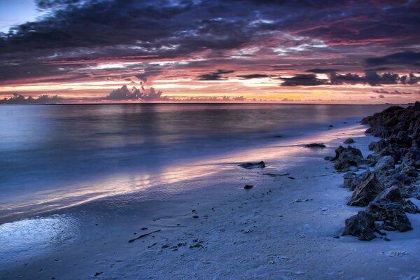 Au bord de la mer des pierres. Coucher de soleil et nuages