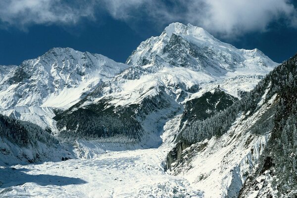 Montagne innevate. Nuvole e foresta