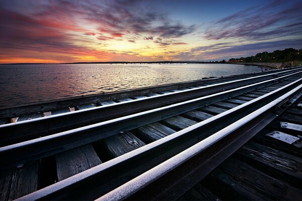 Rails extending into the distance on the seashore