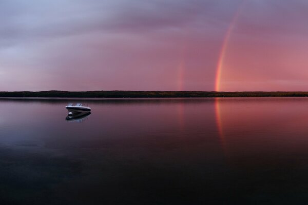 Pink evening with a rainbow on the lake