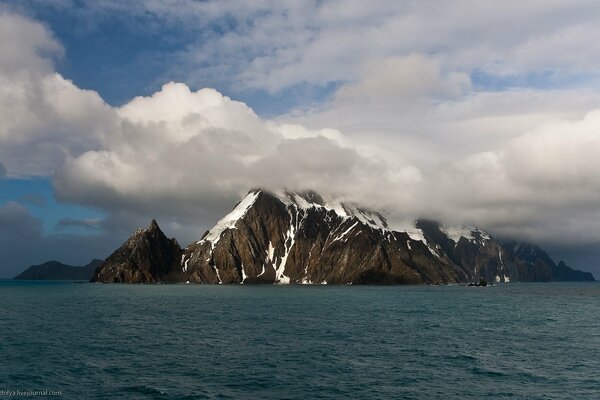 Hoher Felsen im Meer vor dem Hintergrund der Wolken