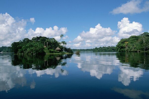 An island with a bungalow in the middle of the sea