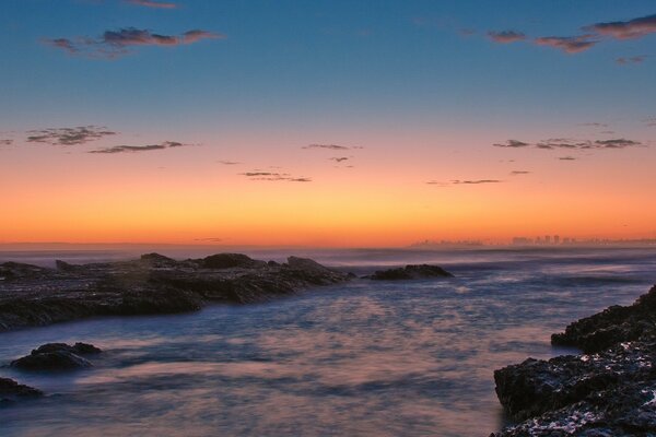 Costa rocosa en el fondo de la puesta de sol