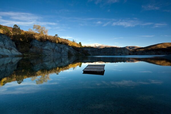 Image of crystal clear water in a lake against the background of mountains and sky