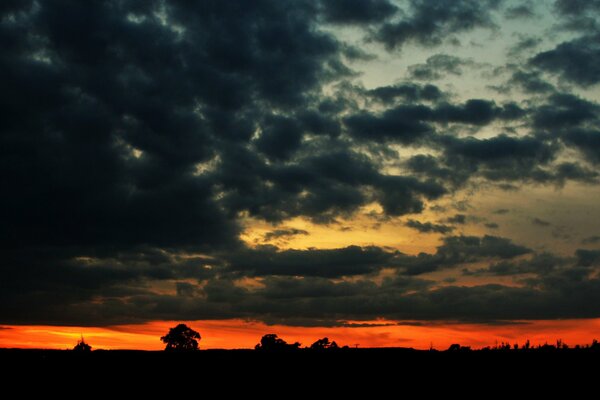 Tramonto arancione attraverso le nuvole scure