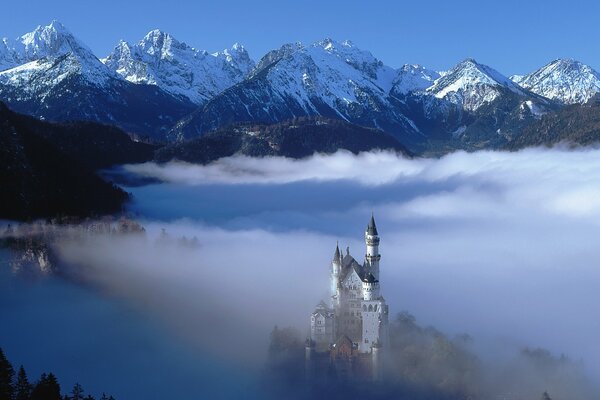 Château mystérieux dans les montagnes tôt le matin dans le brouillard