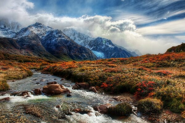 Rivière de montagne et sommets dans les nuages