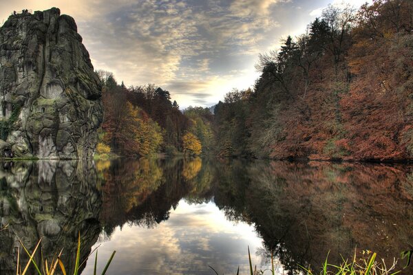 Herbstbäume und Felsen in der Reflexion des Wassers des Sees