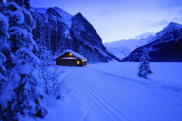 Casa en el bosque cubierto de nieve de invierno