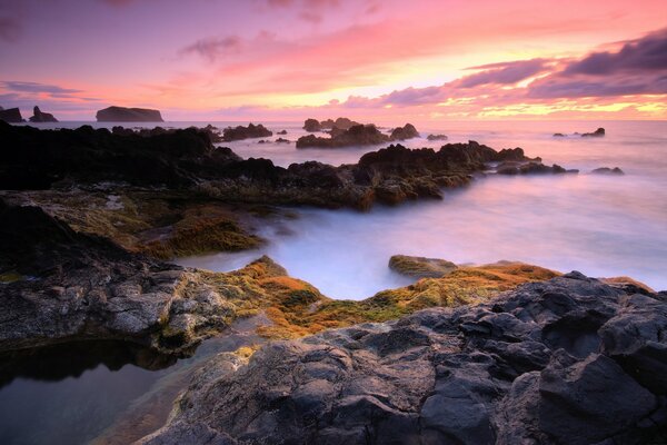 Sunset on the stone shore in silence and fog