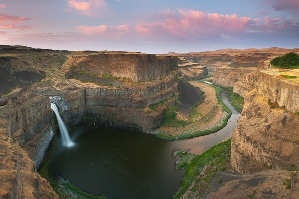 The river flows into the canyon and the waterfall is noisy