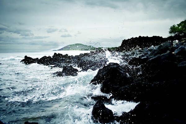 Storm at sea. The water is beating against the rocks