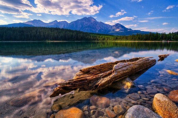 Les nuages se reflètent dans le lac de montagne